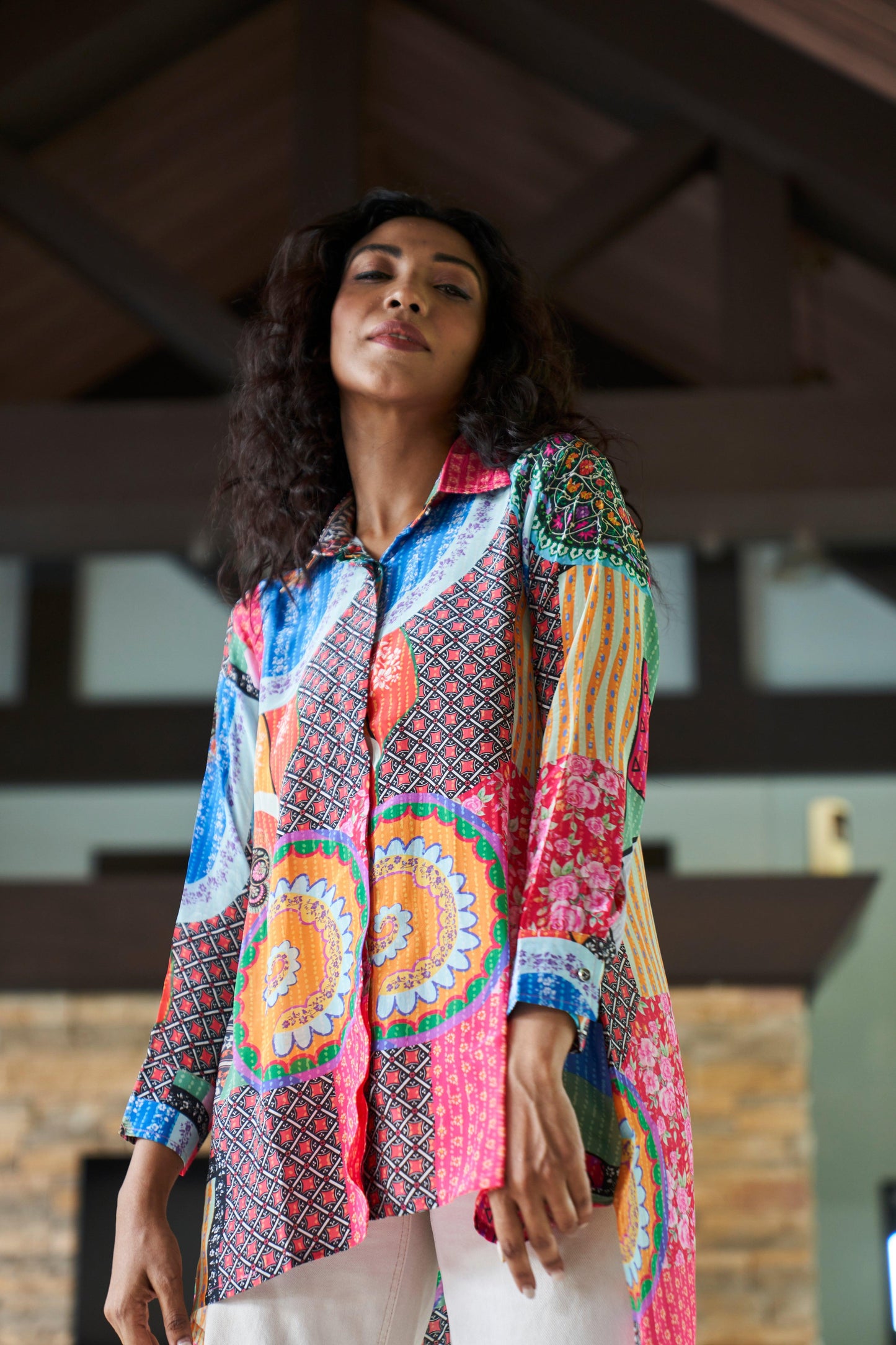 Side view of model wearing abstract print crepe shirt top with relaxed fit and flowy silhouette