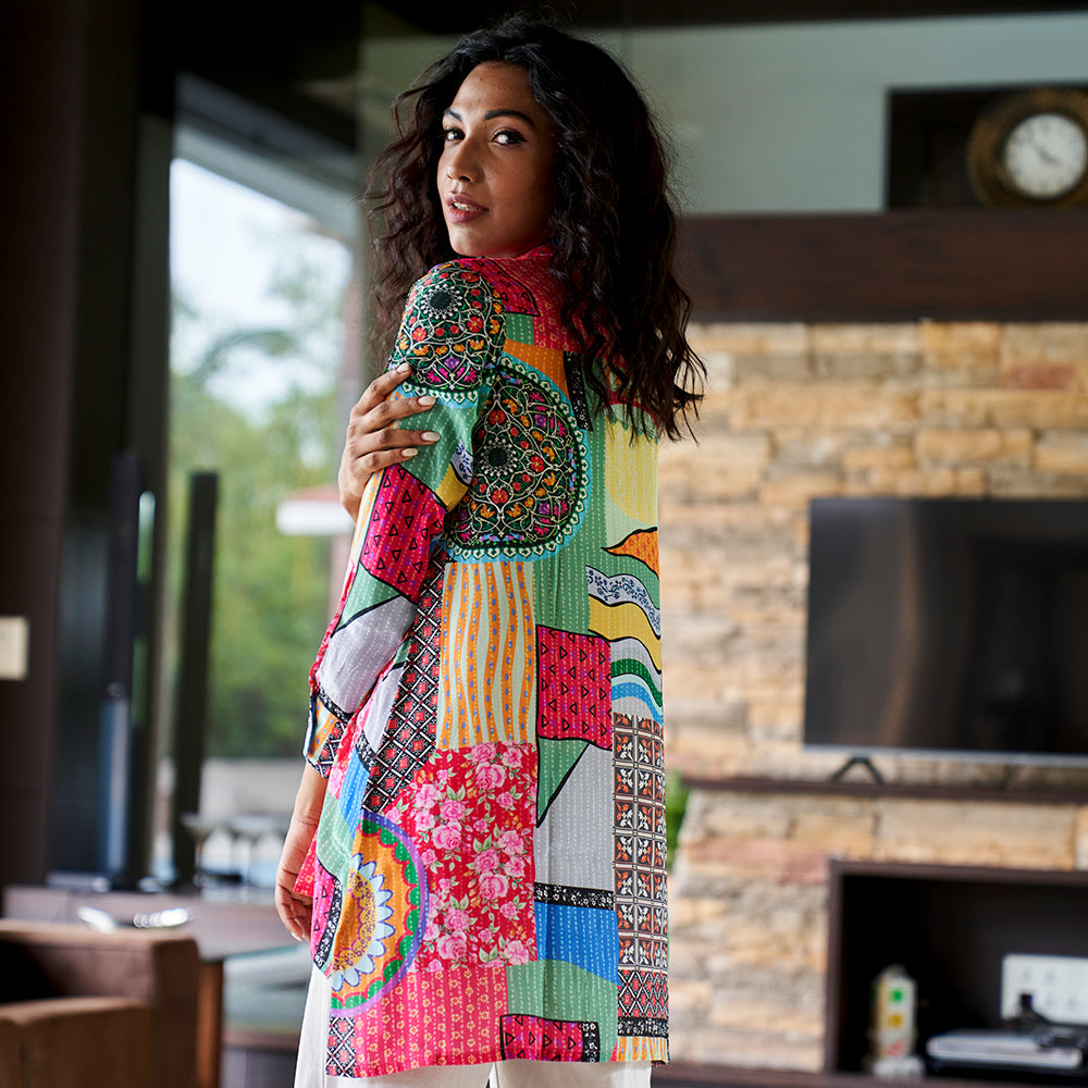 Back view of abstract print crepe shirt top featuring curved hem and soft drape